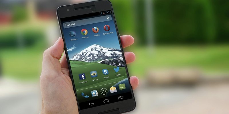Close-up of a smartphone in hand displaying social media apps on screen.