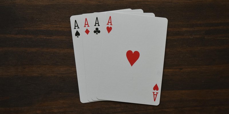Top view of combination of four aces of different suits in poker on wooden table