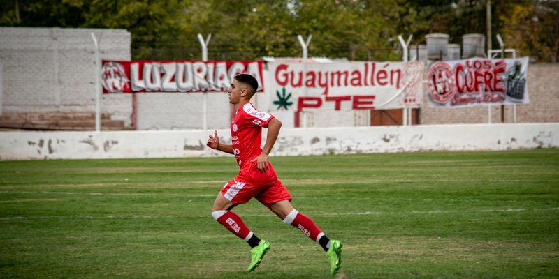 Dynamic shot of a young soccer player running on a football field during a match.