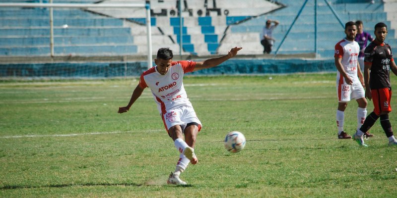 Dynamic moment of a soccer match in Mendoza, Argentina. Players in motion on the grass field.