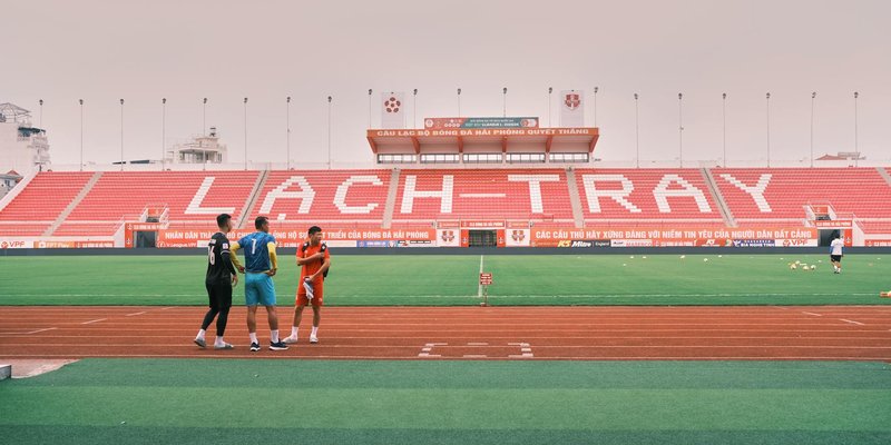 Soccer players gather on the field in Lạch Tray Stadium, Hải Phòng, Vietnam.