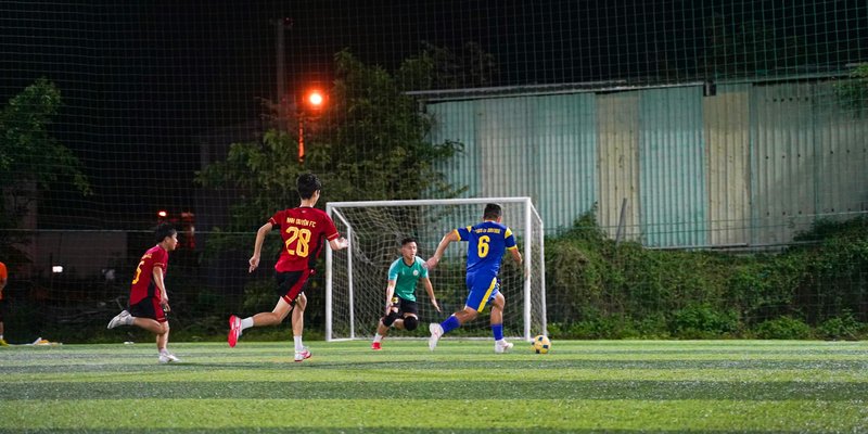 Youth soccer players in action on a lit field at night, showcasing teamwork and energy.
