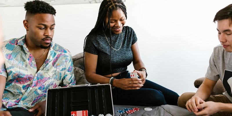 Young friends enjoy a casual card game with poker chips at home.