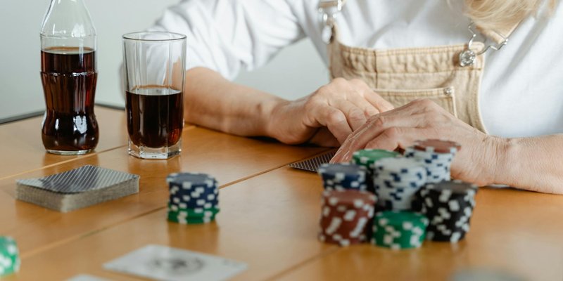 A casual poker game setup with playing cards, poker chips, and refreshing cola drinks.