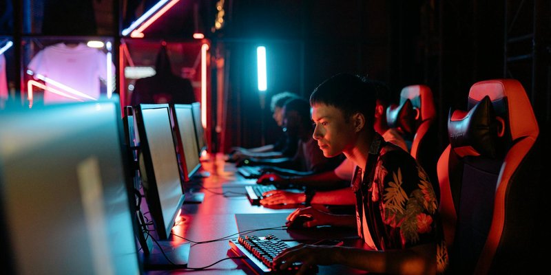 A group of focused gamers playing in a neon-lit gaming room, showcasing intense concentration and mo