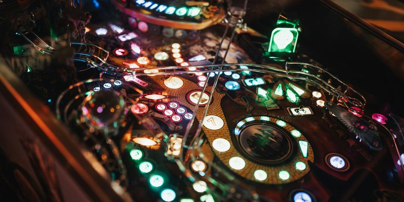 Colorful close-up of an illuminated pinball machine showcasing detailed game mechanics.